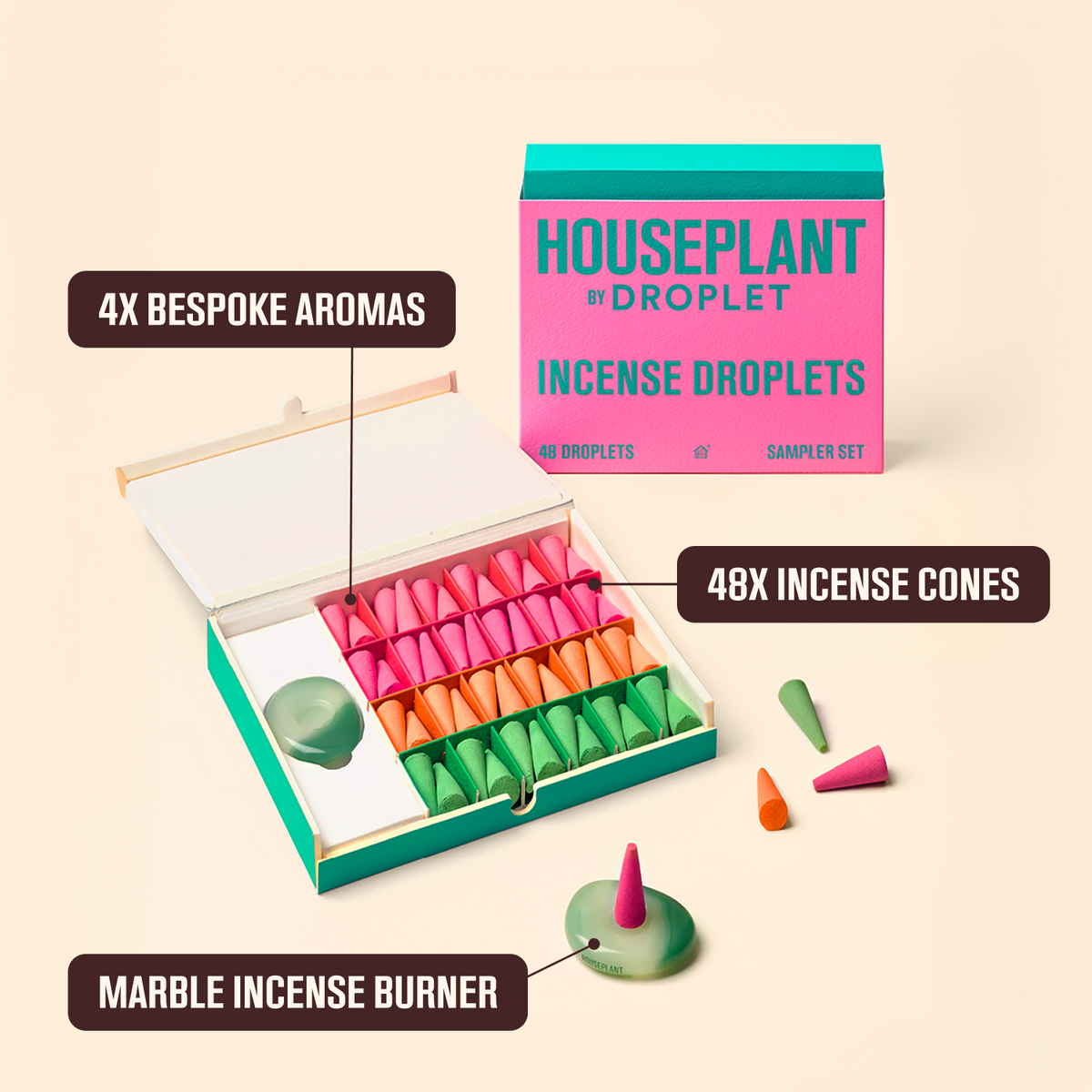 A boxed set of Houseplant by Droplet incense droplets shown open with multiple colored cone-shaped incense pieces arranged inside and a few placed outside. The packaging is bright pink and teal, and the incense pieces are pink, orange, and green.