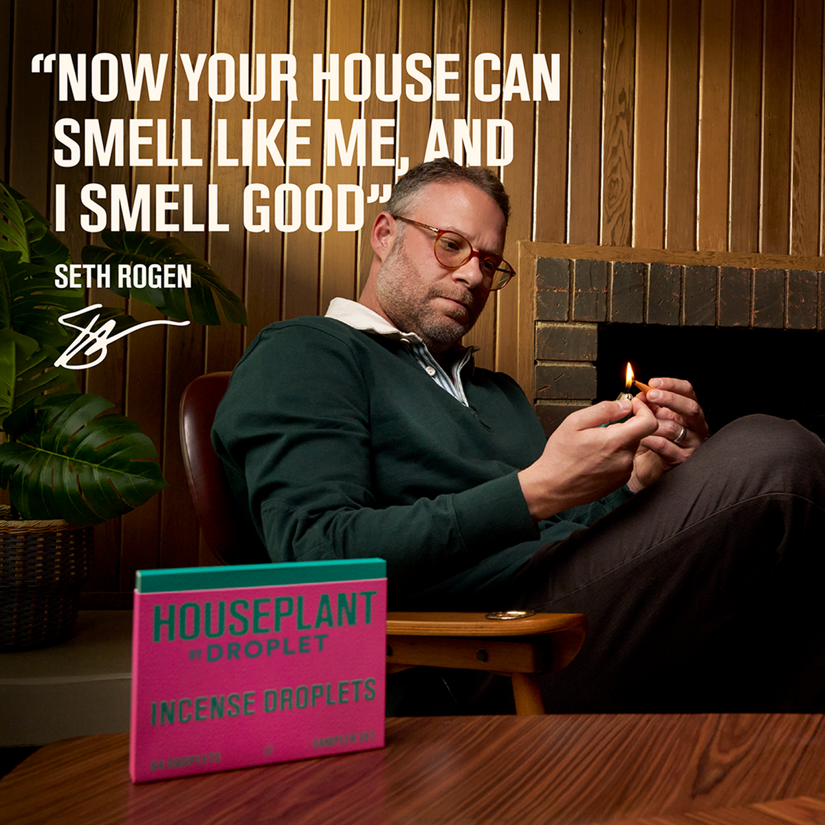 Man lighting a candle with a quote by Seth Rogen and a product box on a wooden table.
