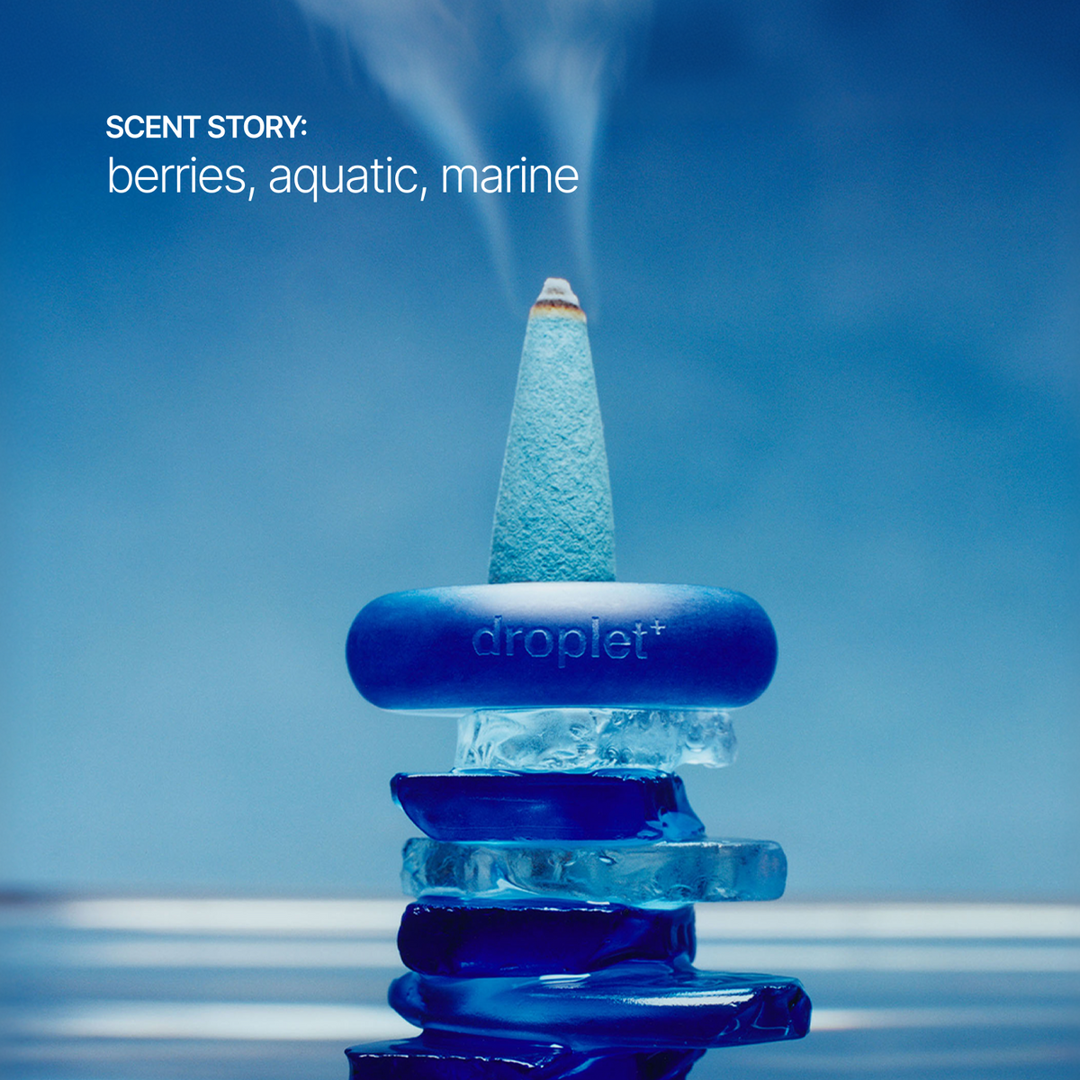A blue droplet incense holder with a smoking incense cone, stacked on translucent blue ice slices against a blue background. White text in the upper left reads 'SCENT STORY: berries, aquatic, marine'.