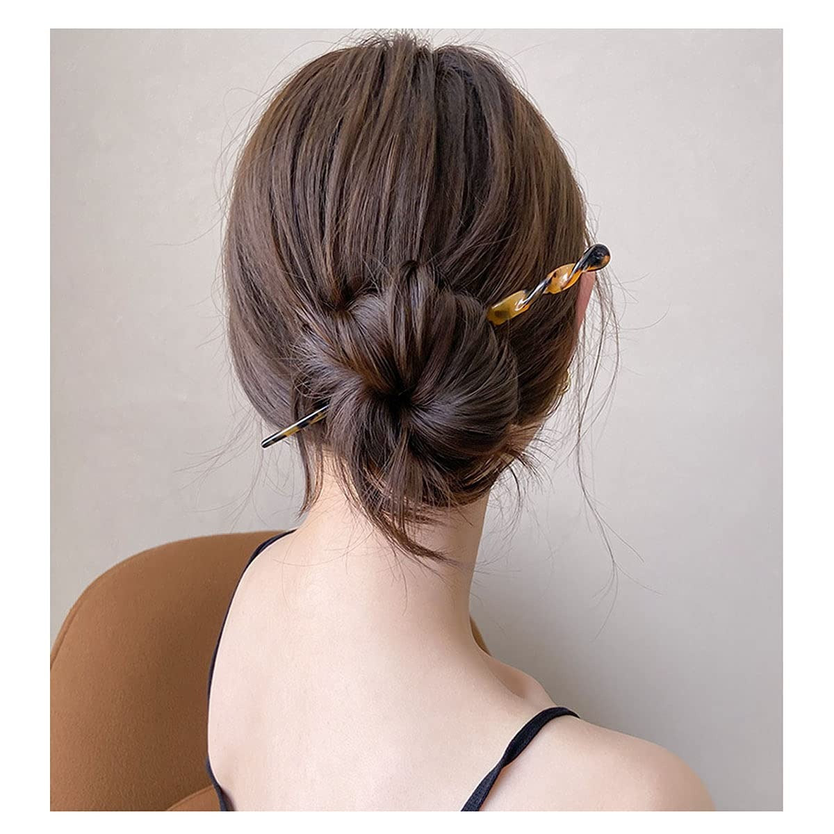 Person with hair styled in an updo using Medusa's French Hair Stick against a neutral background