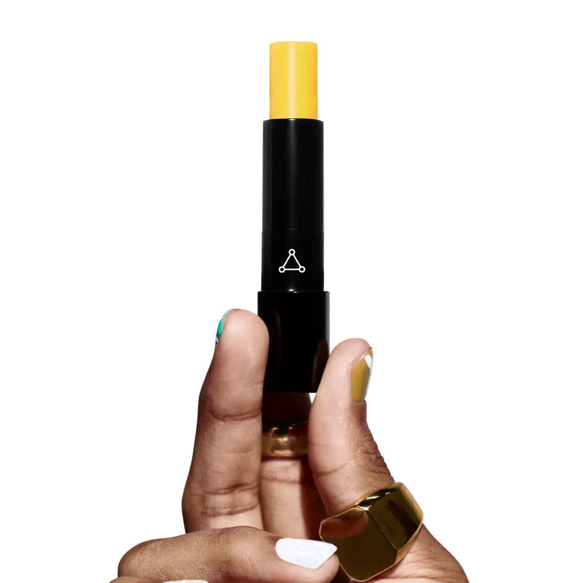 Hand holding a black cosmetic stick with yellow top on a white background