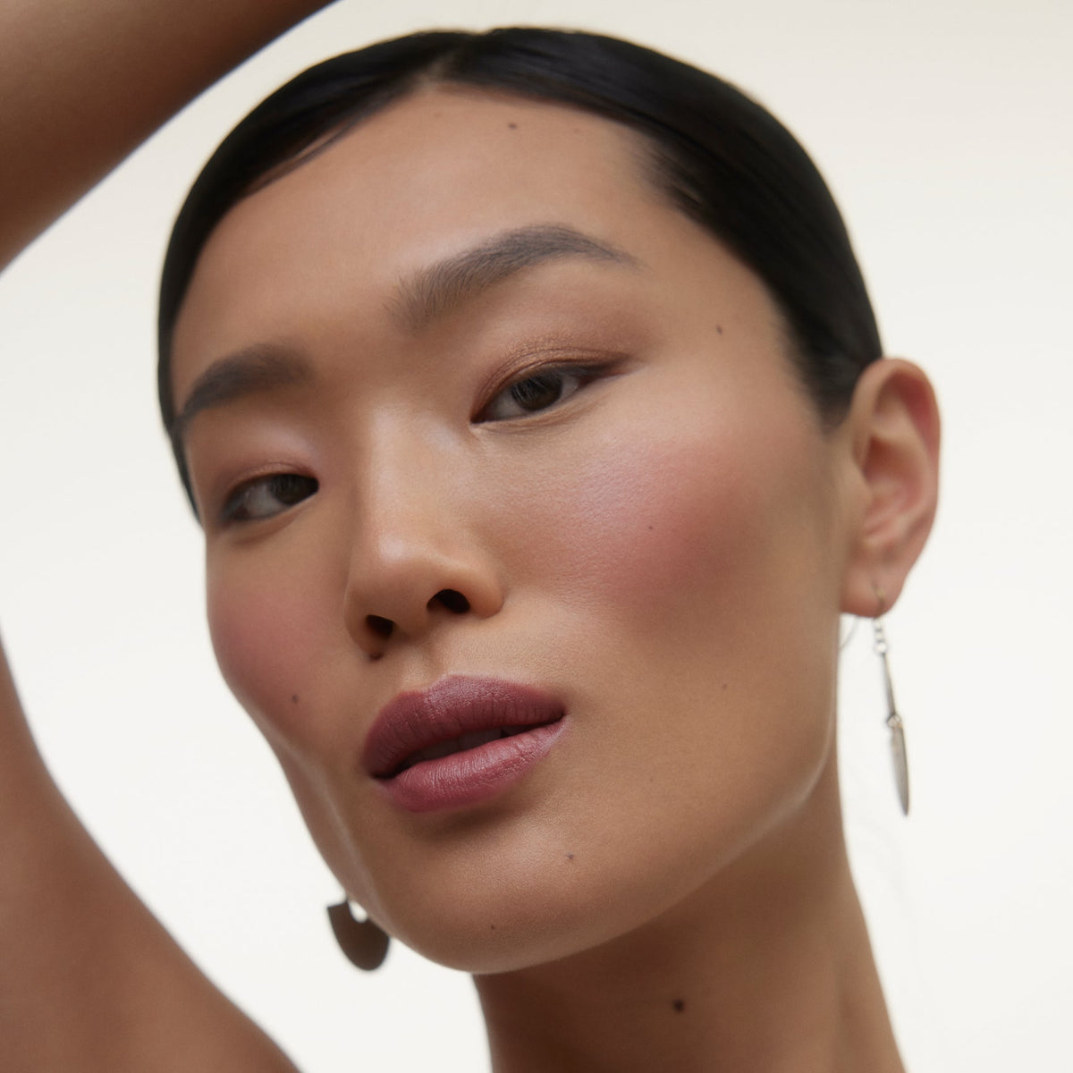 Close up of a woman's face wearing Wonderblush makeup.