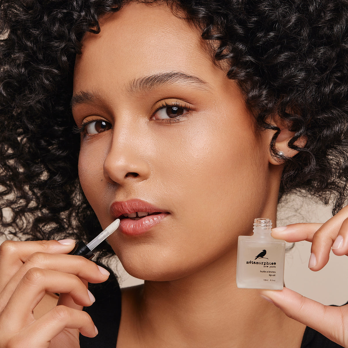 Woman applying Metamorphose's Lip Oil.
