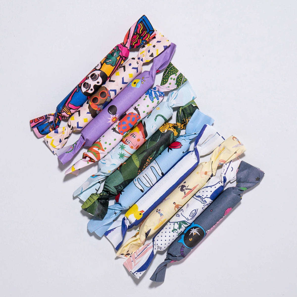Maison Matine Perfume Minis wrapped in colorful papers on a light gray background
