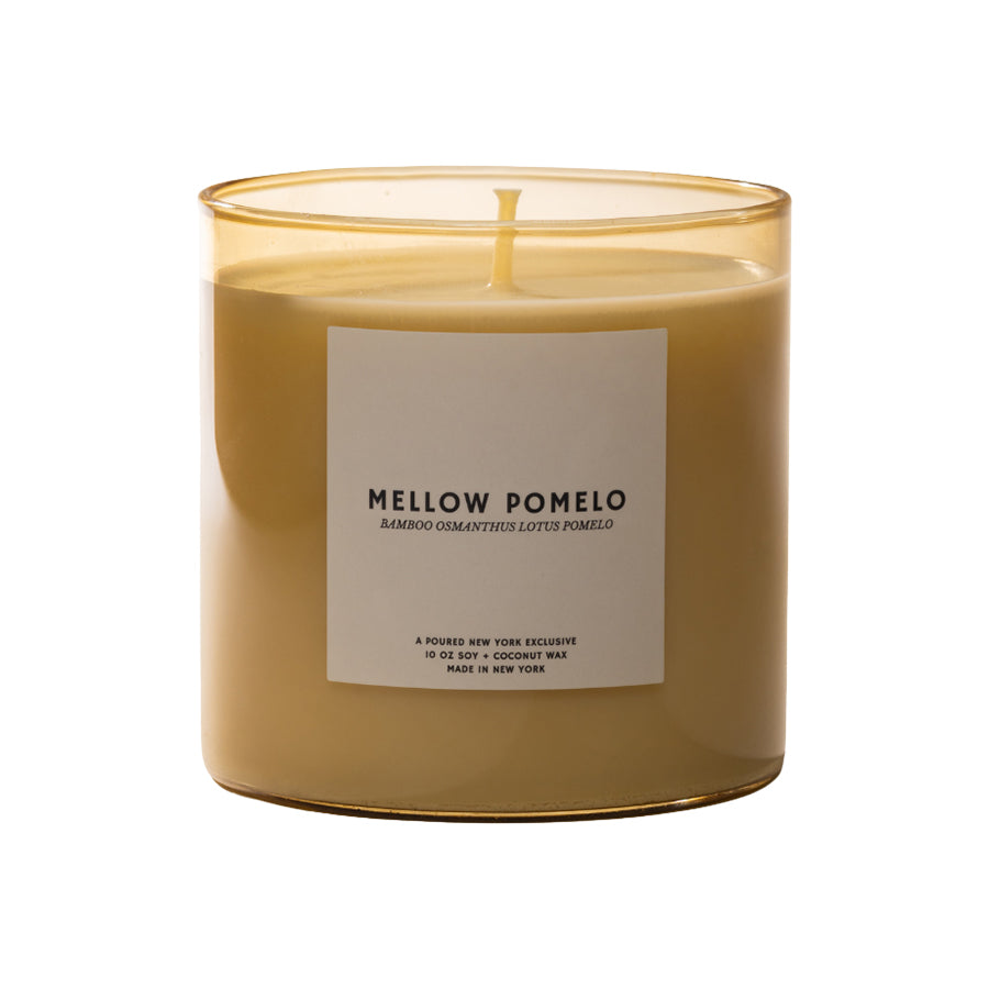 Candle with a label reading 'Mellow Pomelo' on a white background