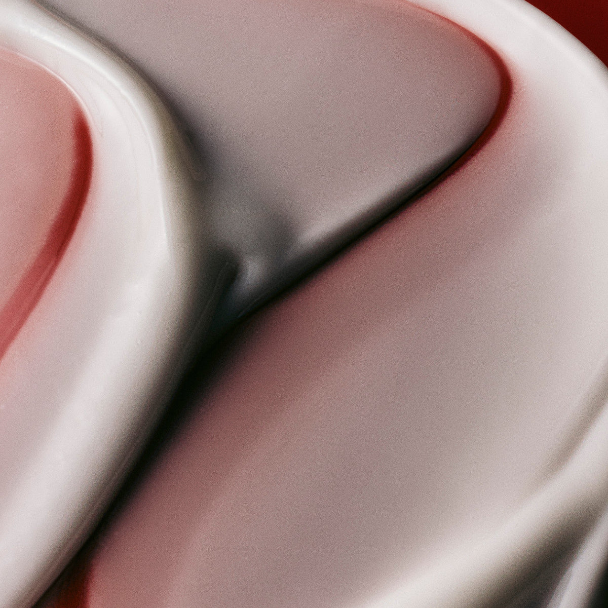 Texture swatch of Mienne's Body Serum on a red surface. 