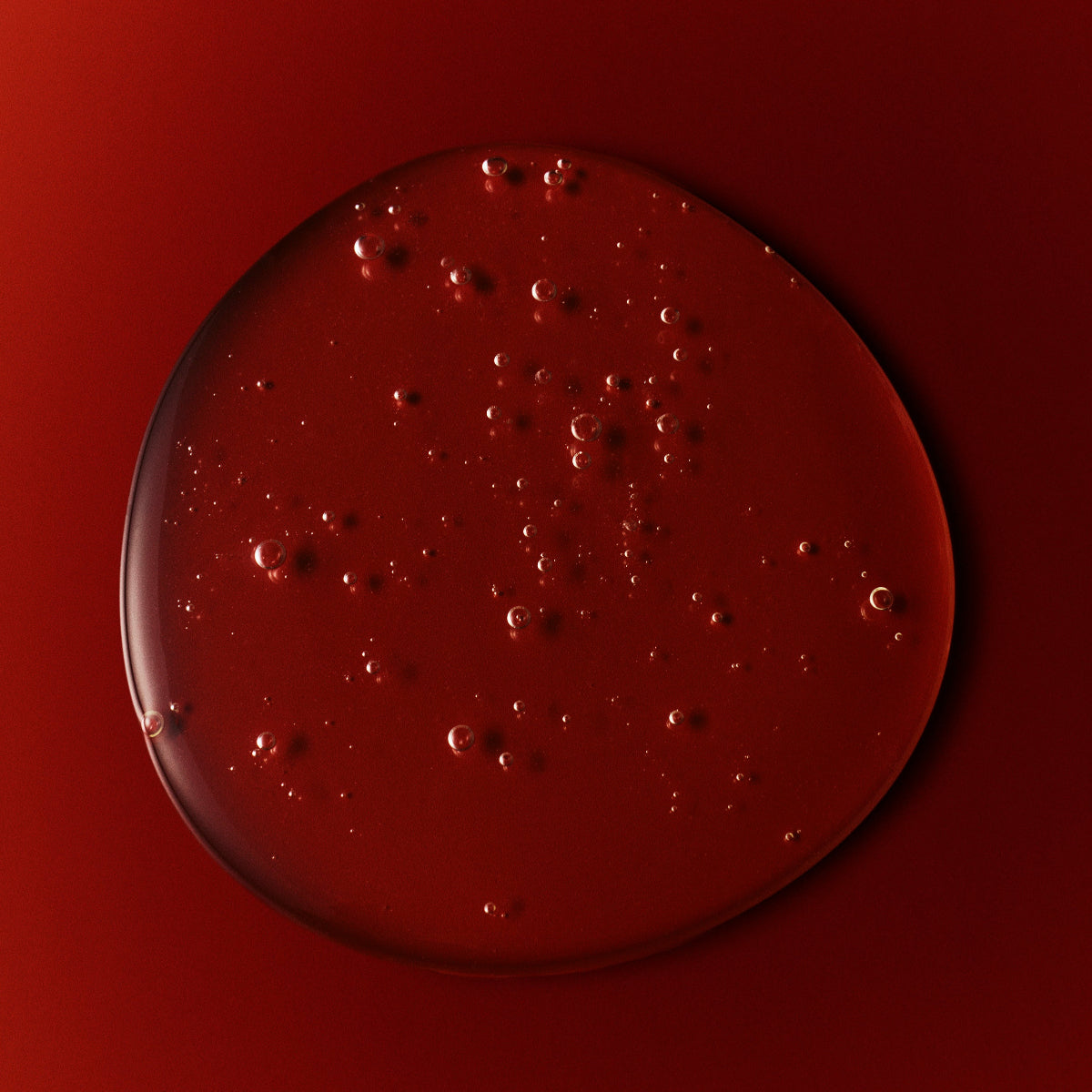 Drop of Mienne's Body Wash on a red surface. 