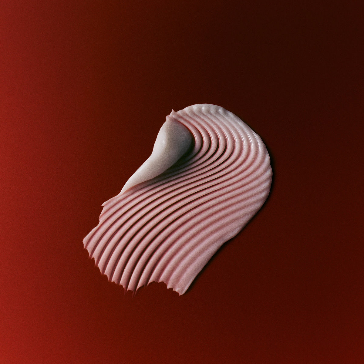 Texture swatch of Mienne Hand Cream on a red surface. 