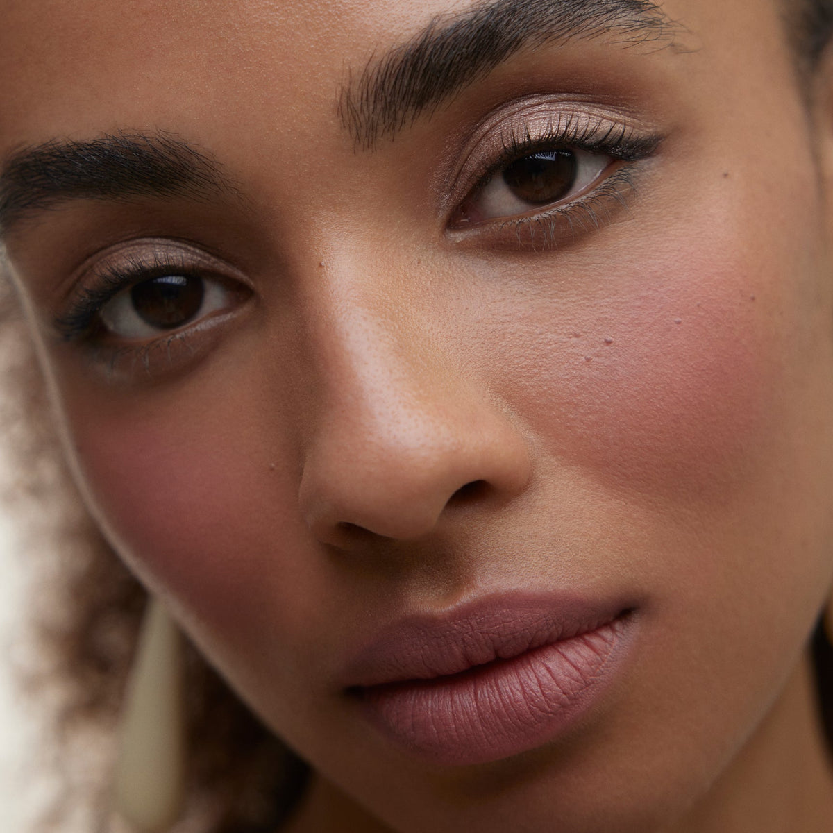 Close up of a woman's face wearing Wonderblush makeup.