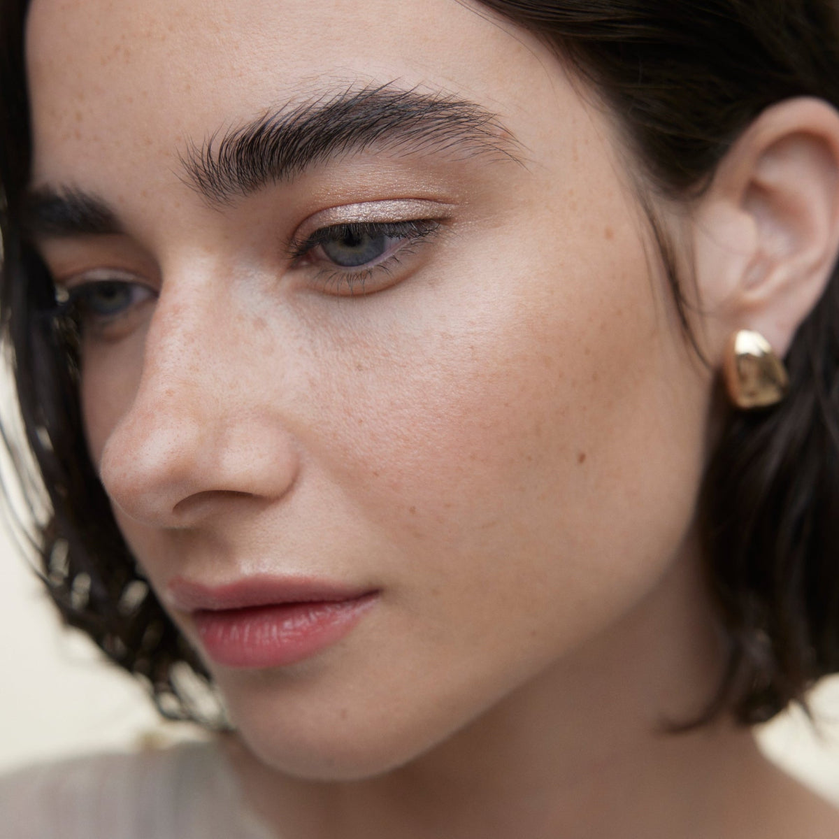 Closeup of woman's face wearing Wonderblush makeup products. 