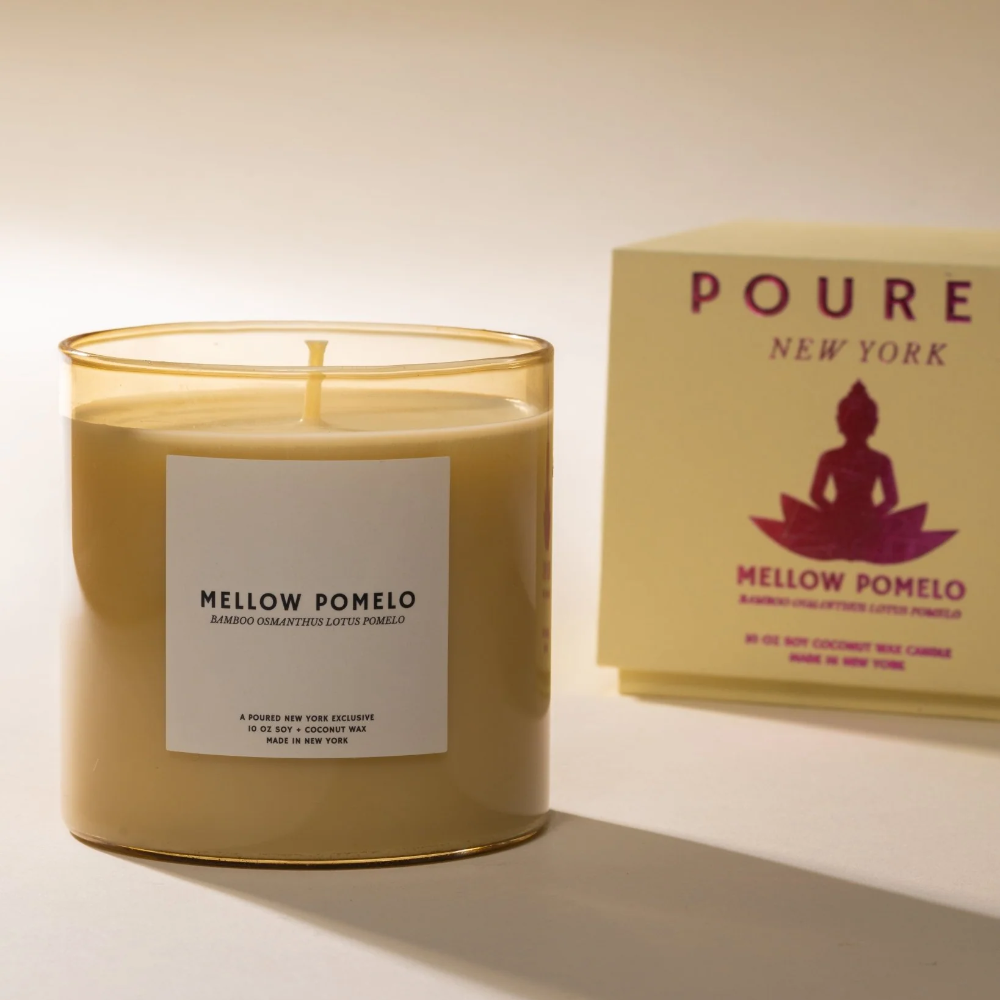 Candle labeled 'Mellow Pomelo' with a 'POURED New York' box in the background.