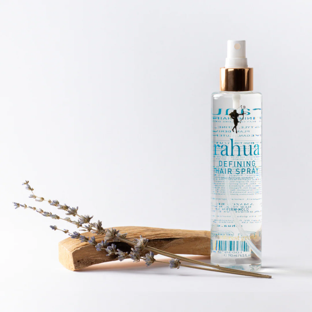Rahua Defining Hair Spray bottle with dried lavender on a white background.