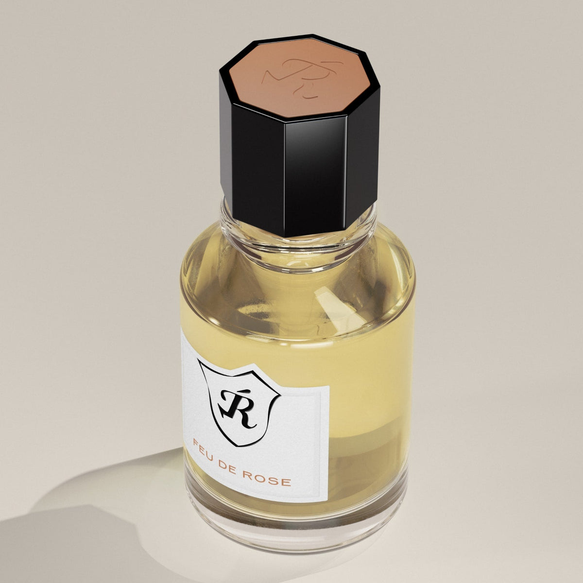 Perfume bottle labeled 'EAU DE ROSE' with a black cap on a beige background