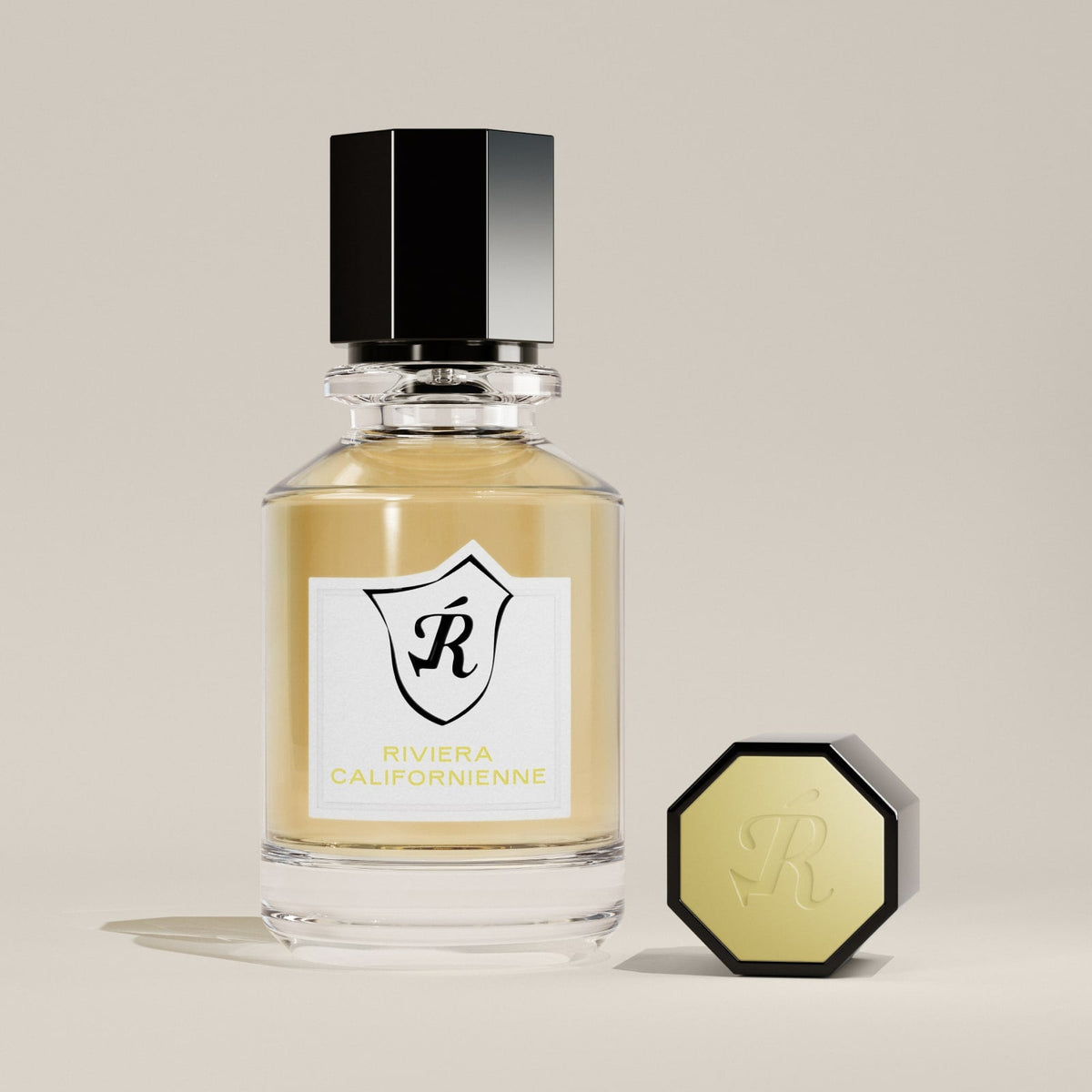 Perfume bottle with black cap and gold body on a beige background