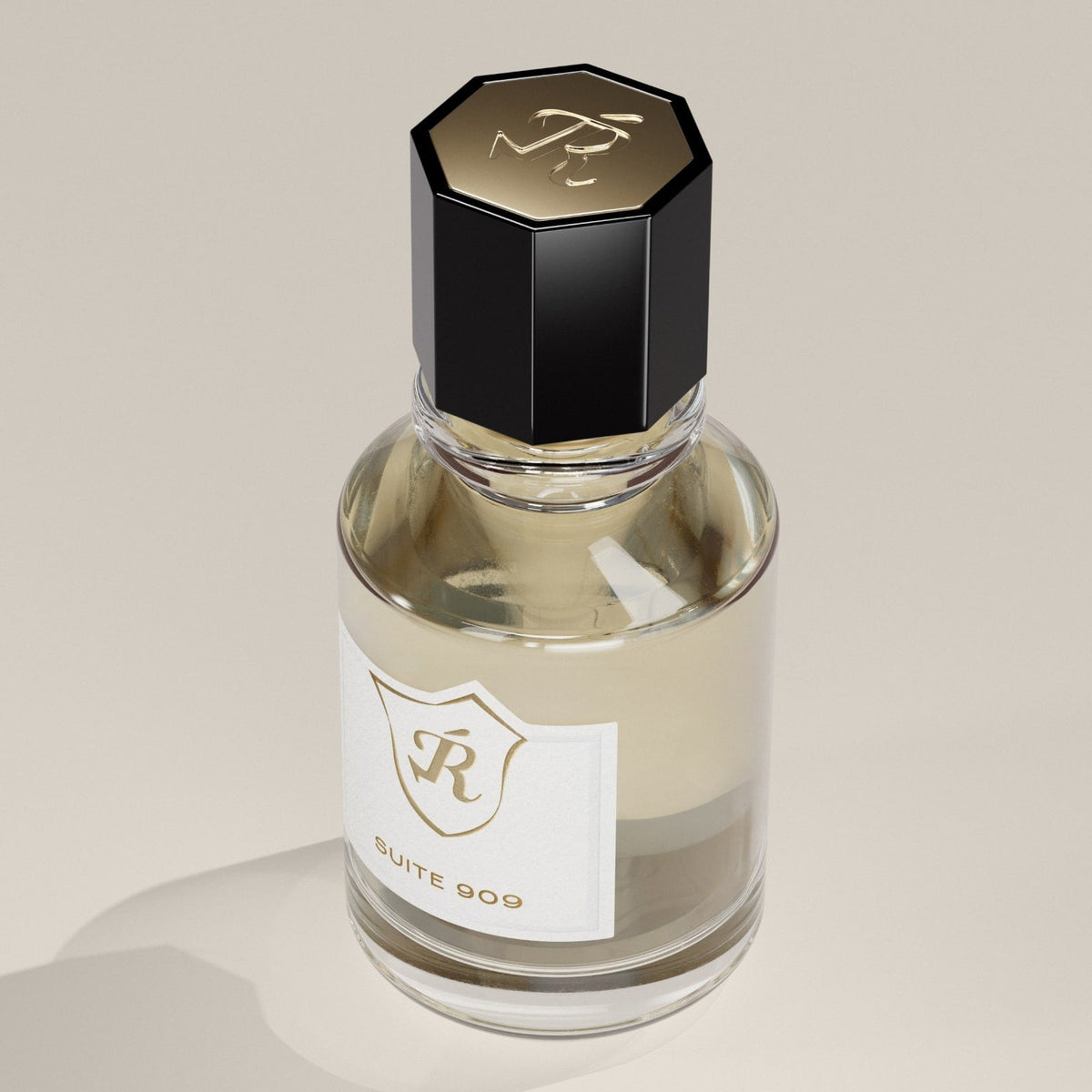 Perfume bottle with a black cap and white label on a beige background