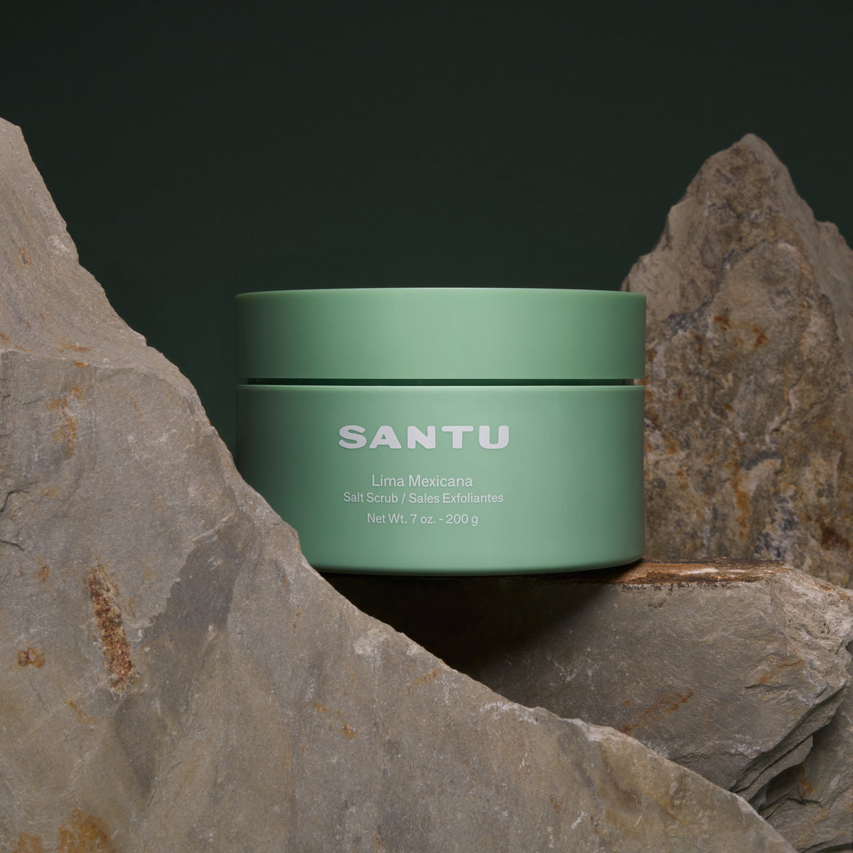 Green jar labeled 'SANTU' on a stone surface with a dark background