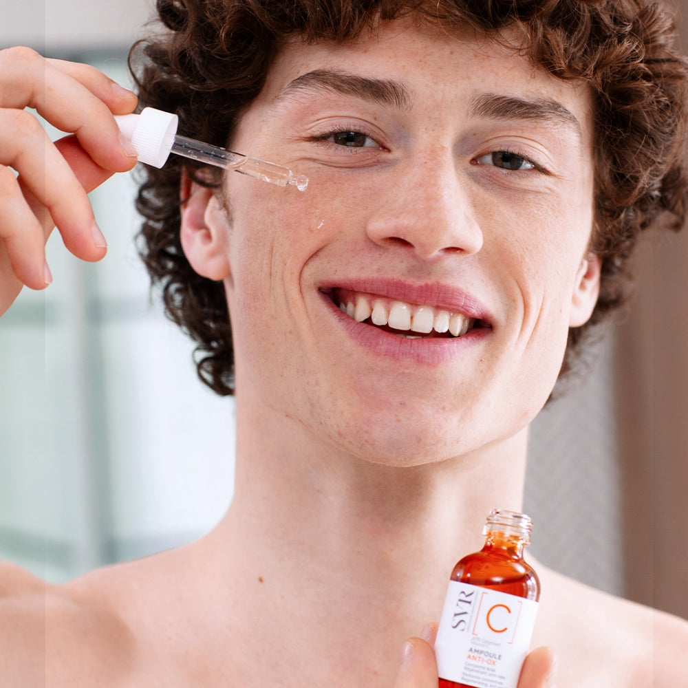 Person applying SVR Radiance Concentrate  product with dropper on a blurred background
