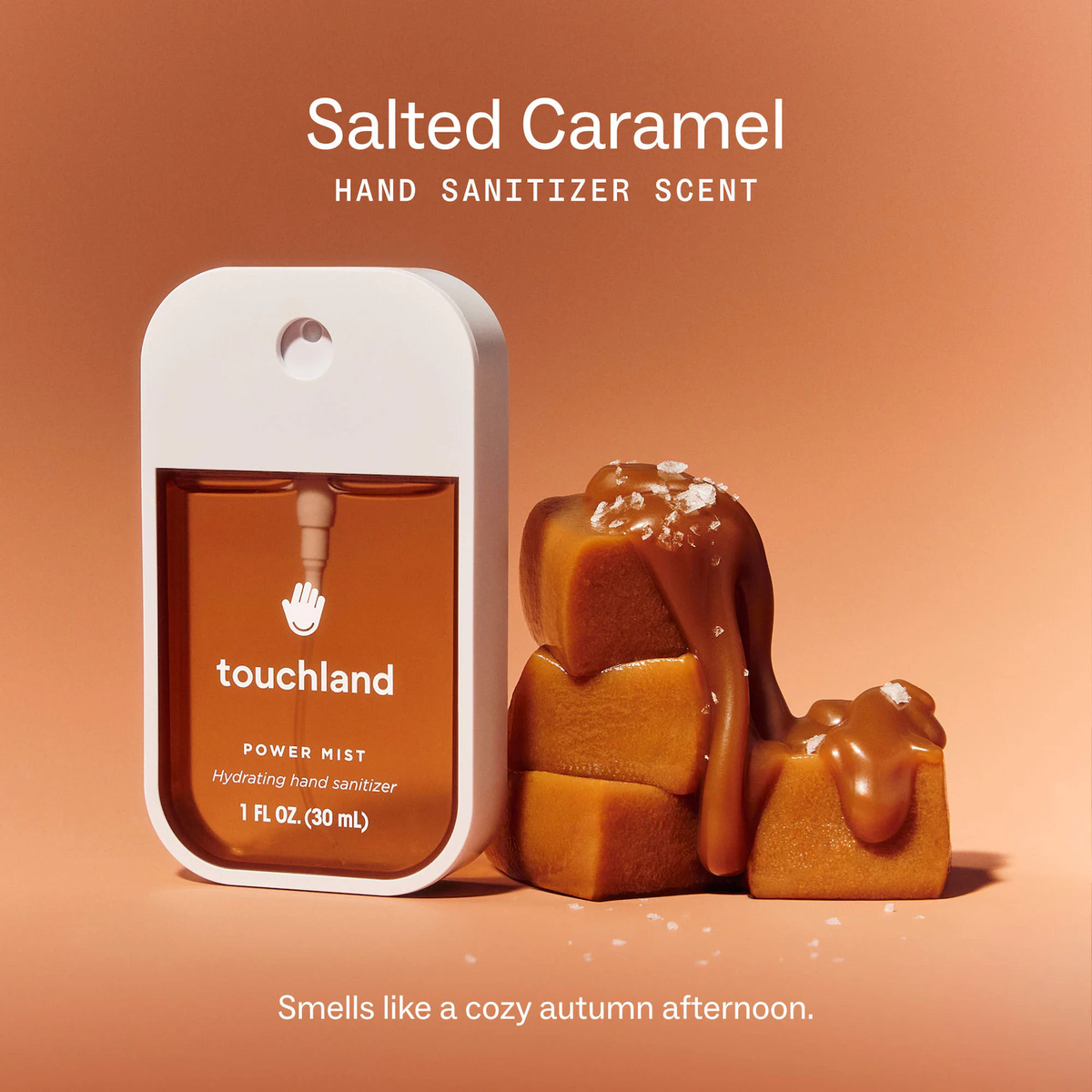 A Touchland hand sanitizer bottle labeled 'Salted Caramel' stands next to caramel-coated gummy candies on a warm peach background, with text reading 'Salted Caramel HAND SANITIZER SCENT' and 'Smells like a cozy autumn afternoon.'.
