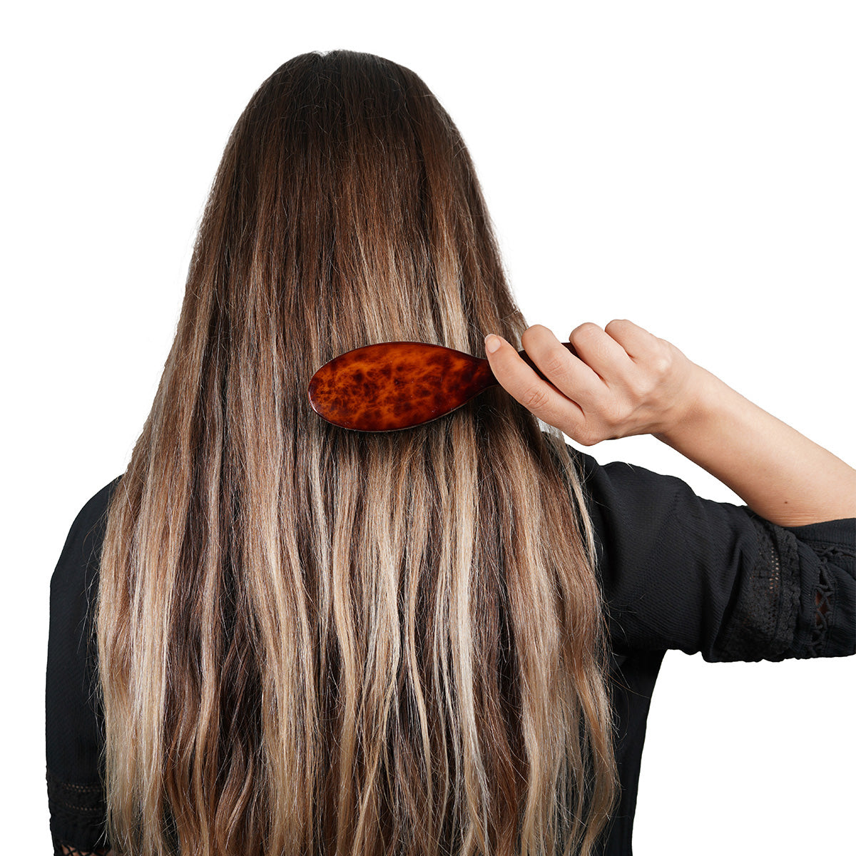 Person with long, wavy hair using C.O. Bigelow Petite Boar Bristle Hairbrush 