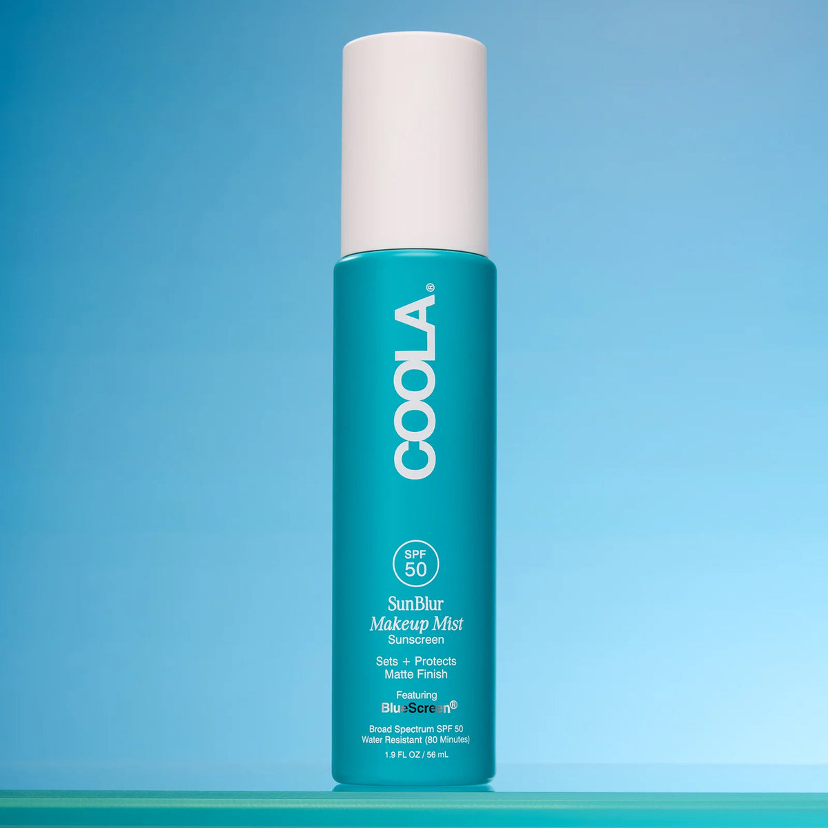 COOLA SunBlur Makeup Mist product on a blue background