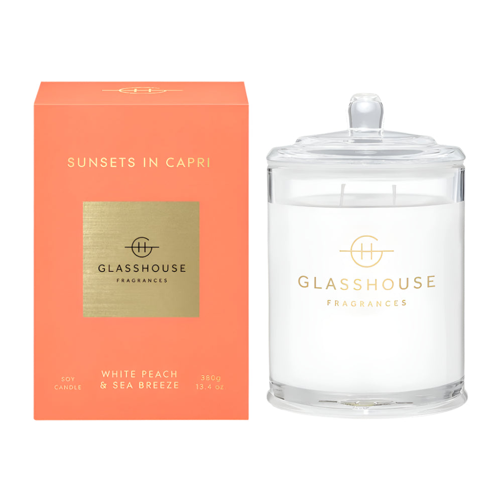 Sunsets in Capri Glass Candle with lid.  Clear glass with logo printed on it.  The peach colored box it comes in to its left.