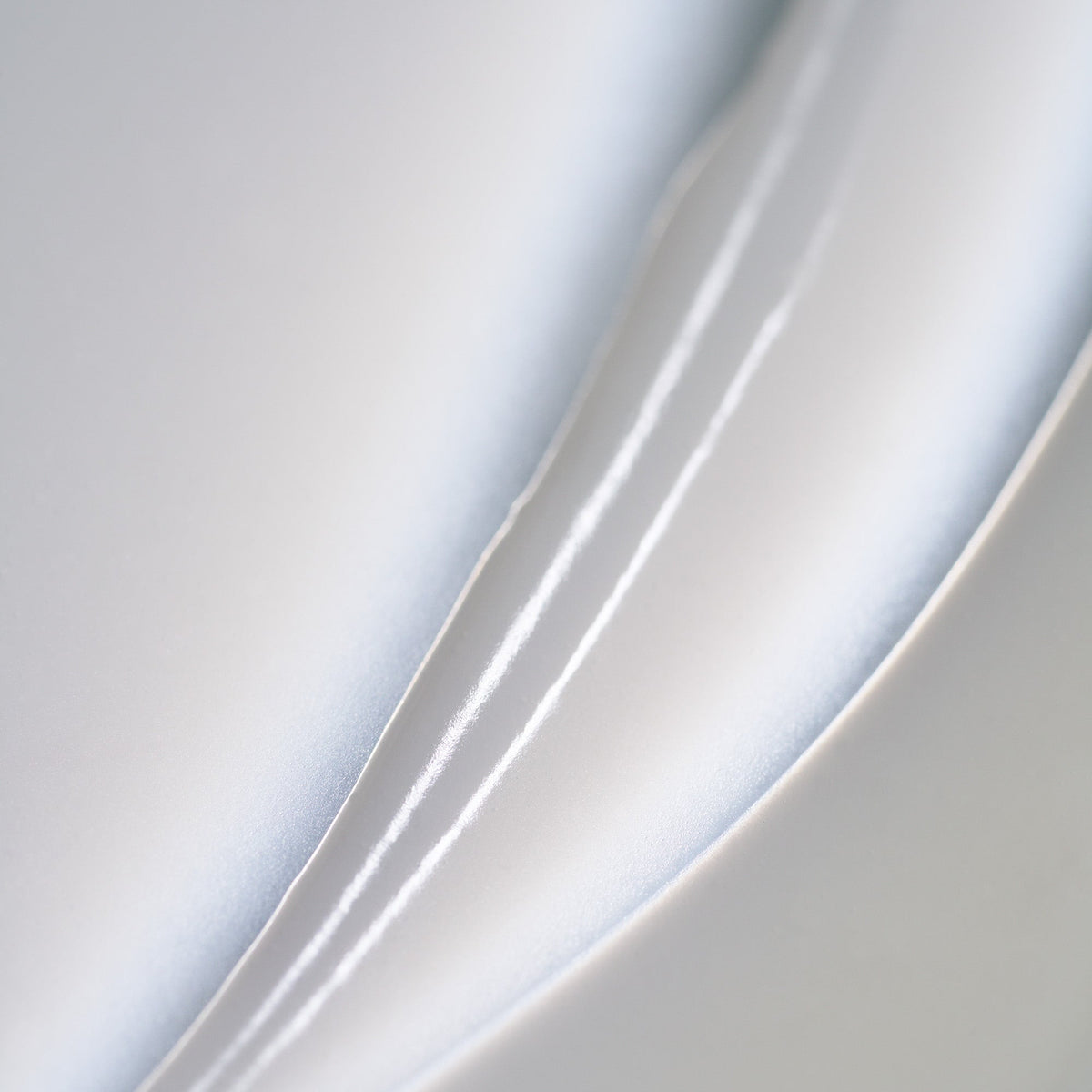 Oribe Supershine Hydrating Conditioner product texture closeup.