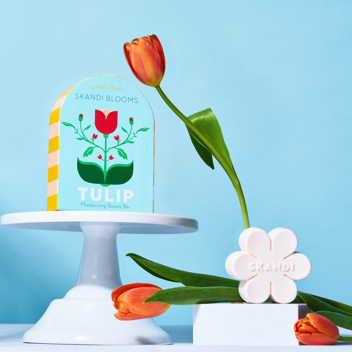 Kala Style Skandi Blooms Tulip Moisturizing Beauty Bar box in front of blue background around fresh tulips.