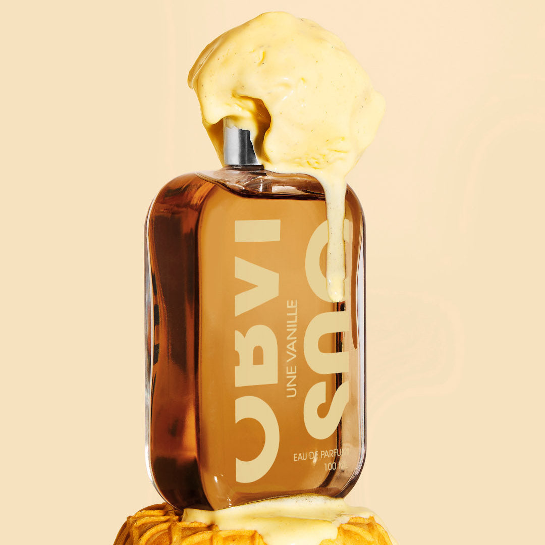 Perfume bottle covered in ice cream on a beige background