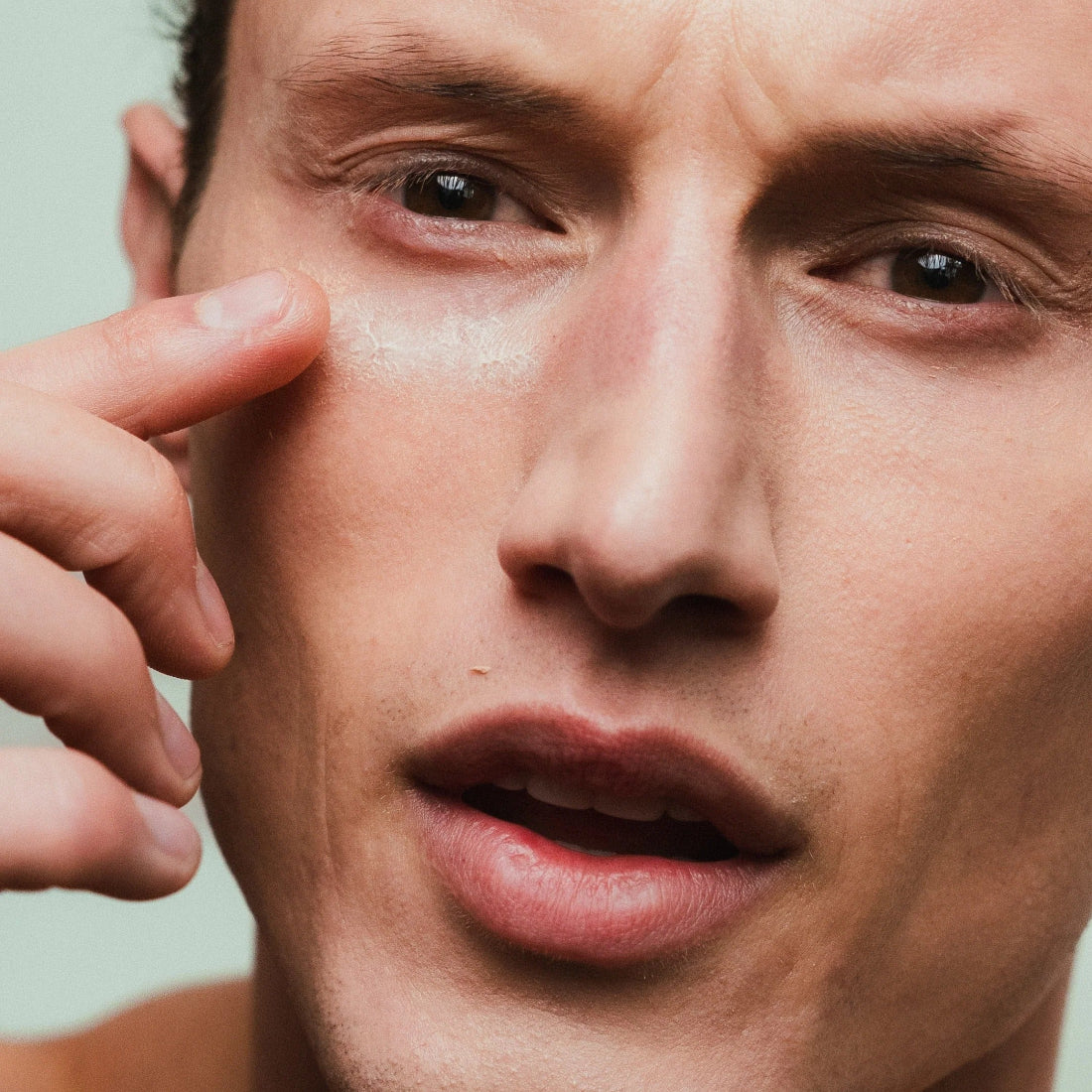 Man applying Y Code Well Kept Advanced Eye Serum Tube in Formula M to his undereye.