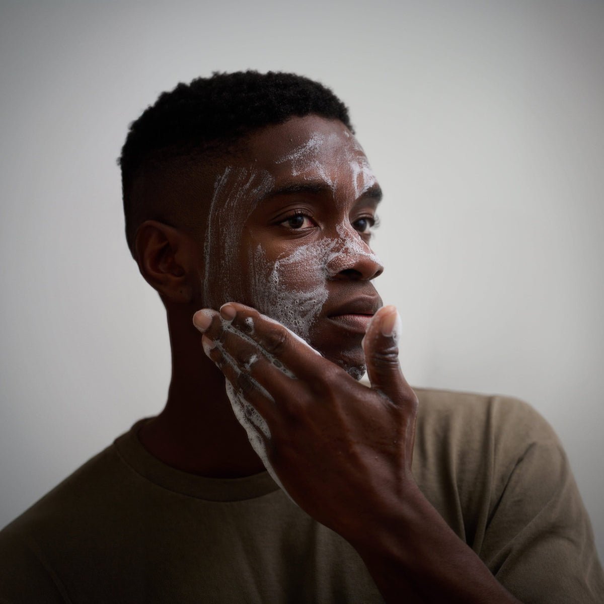 Man washing his face with Bravo Sierra's Unscented Face & Body Cleansing Bar.