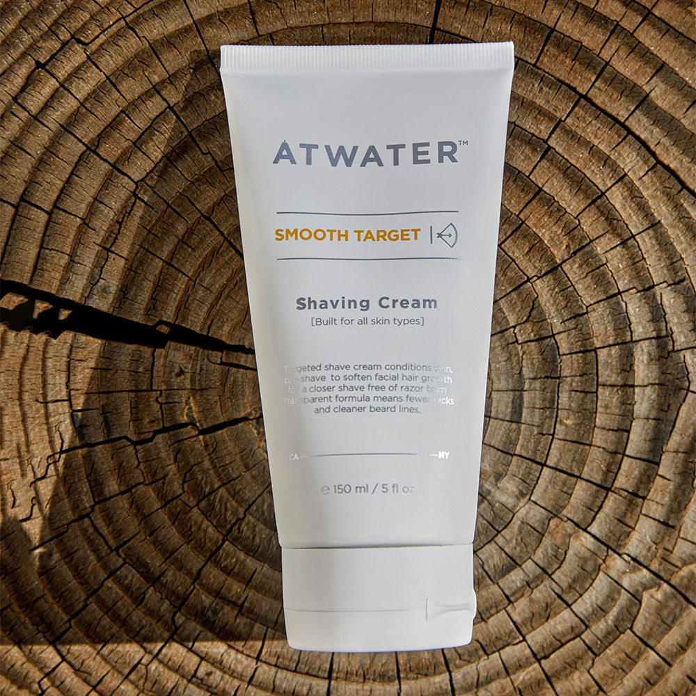 A tube of ATWATER Smooth Target Shaving Cream against a white background on a tree trunk