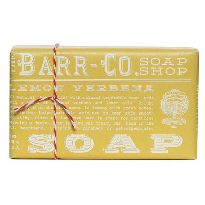 A yellow bar of soap with white text and a red ribbon on top, packaged with product information.