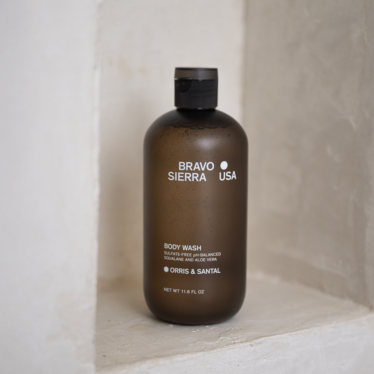 Bravo Sierra Orris & Santal Body wash on a concrete shelf. 