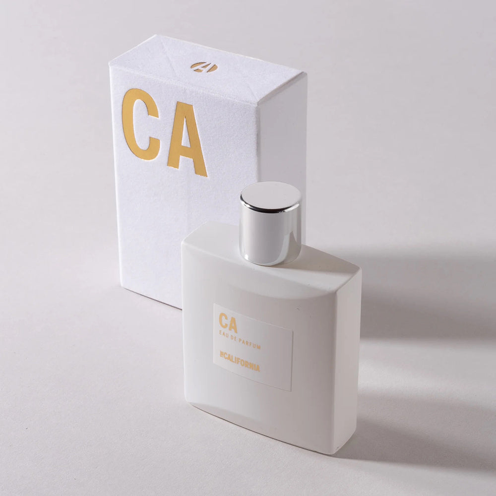Perfume bottle next to its box on a white background