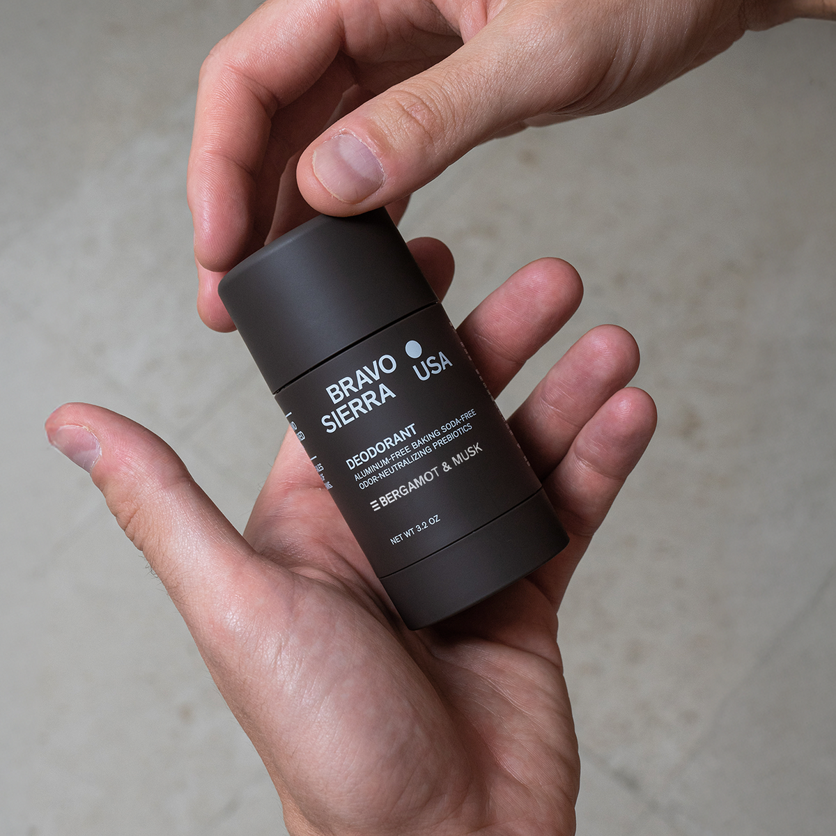 Hands holding Bravo Sierra Bergamot & Musk Deodorant.