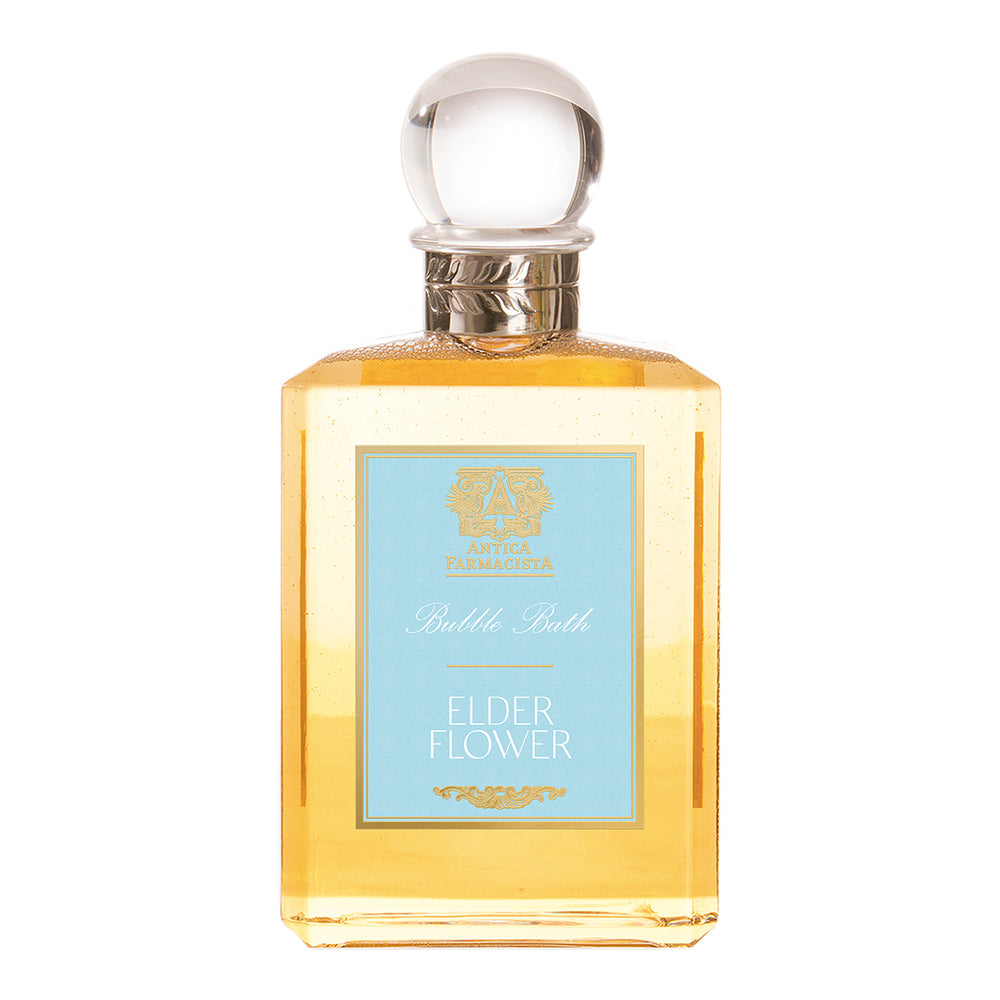 A bottle of Elderflower Bubble Bath with a clear amber liquid visible through the transparent glass, capped with a silver lid.