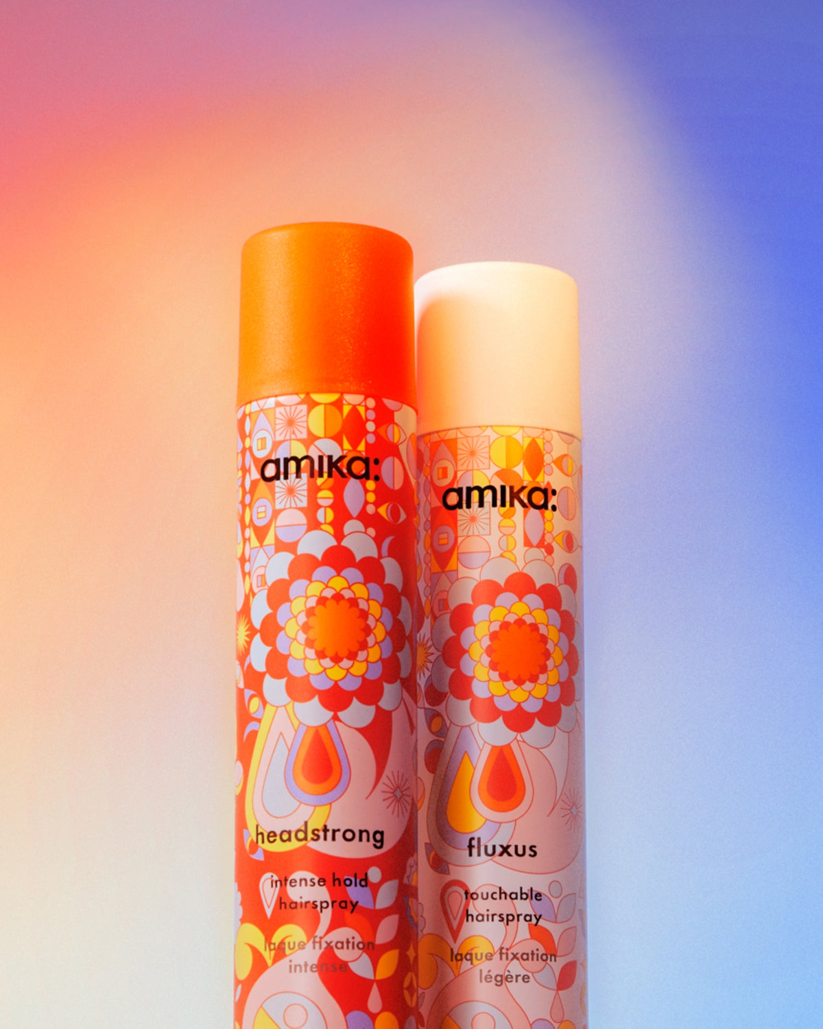 Two bottles of amika hair spray on a colorful gradient background