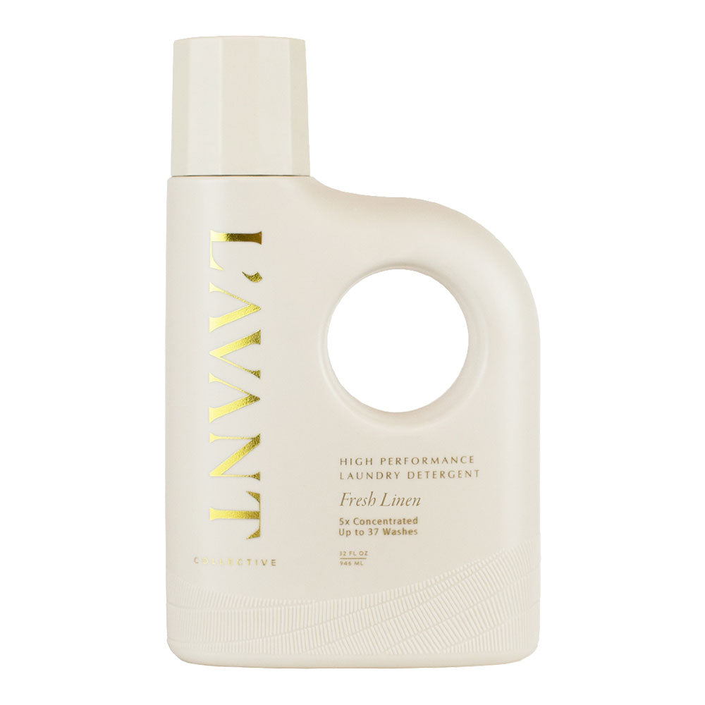 A white bottle of L'AVANT high-performance laundry detergent with a Fresh Linen scent, featuring a minimalist design with gold text and a cut-out circle on the front.