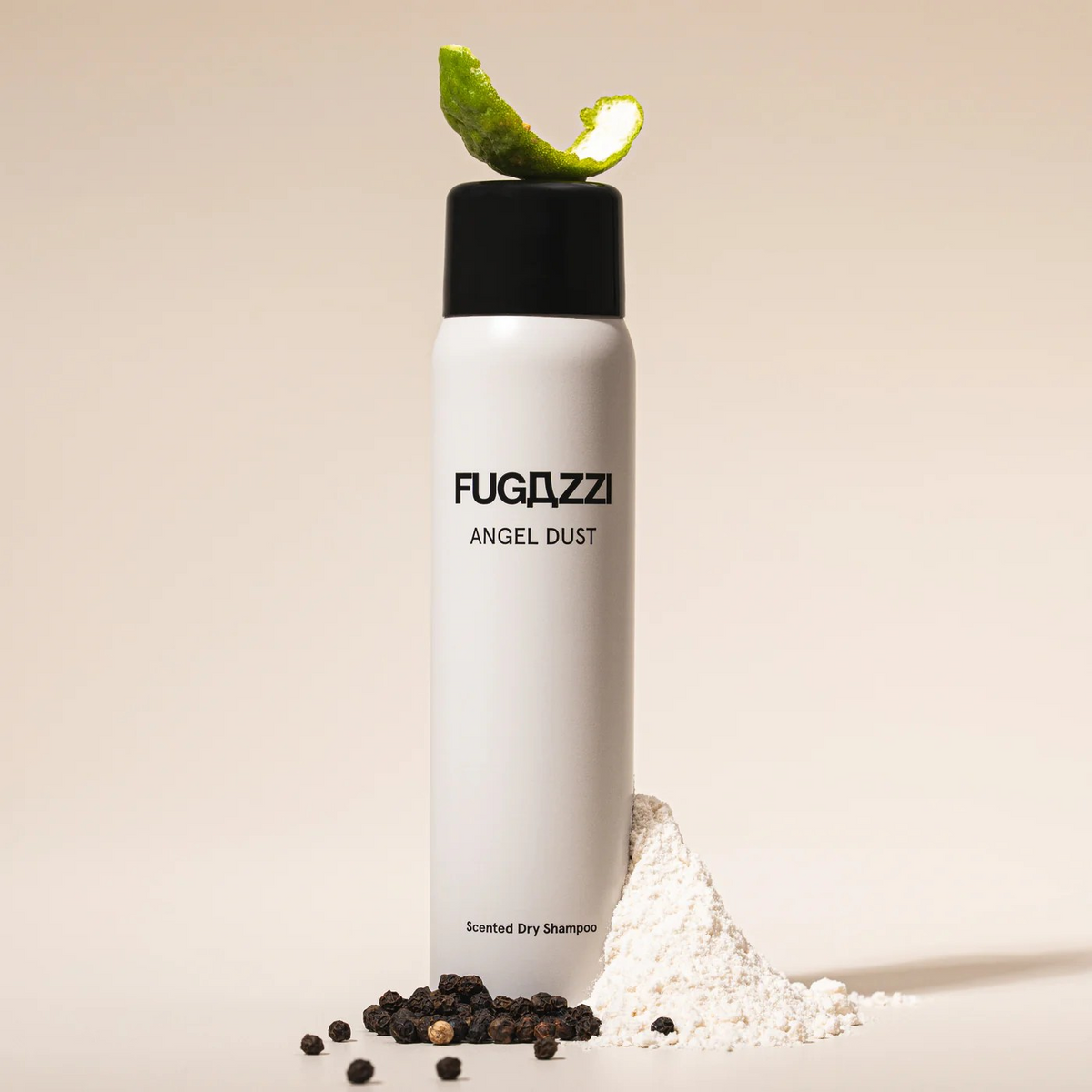 Fugazzi Scented Dry Shampoo canister with a lime peel on top and black peppercorns and white powder below it.