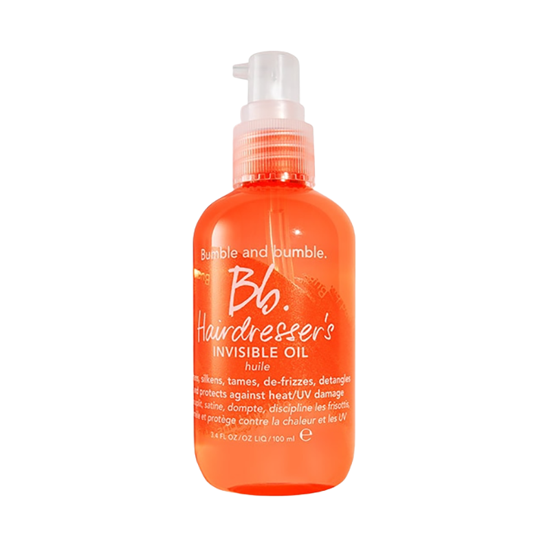 A clear bottle with orange liquid and a white pump, labeled 'Bumble and Bumble Hairdresser's Invisible Oil'.