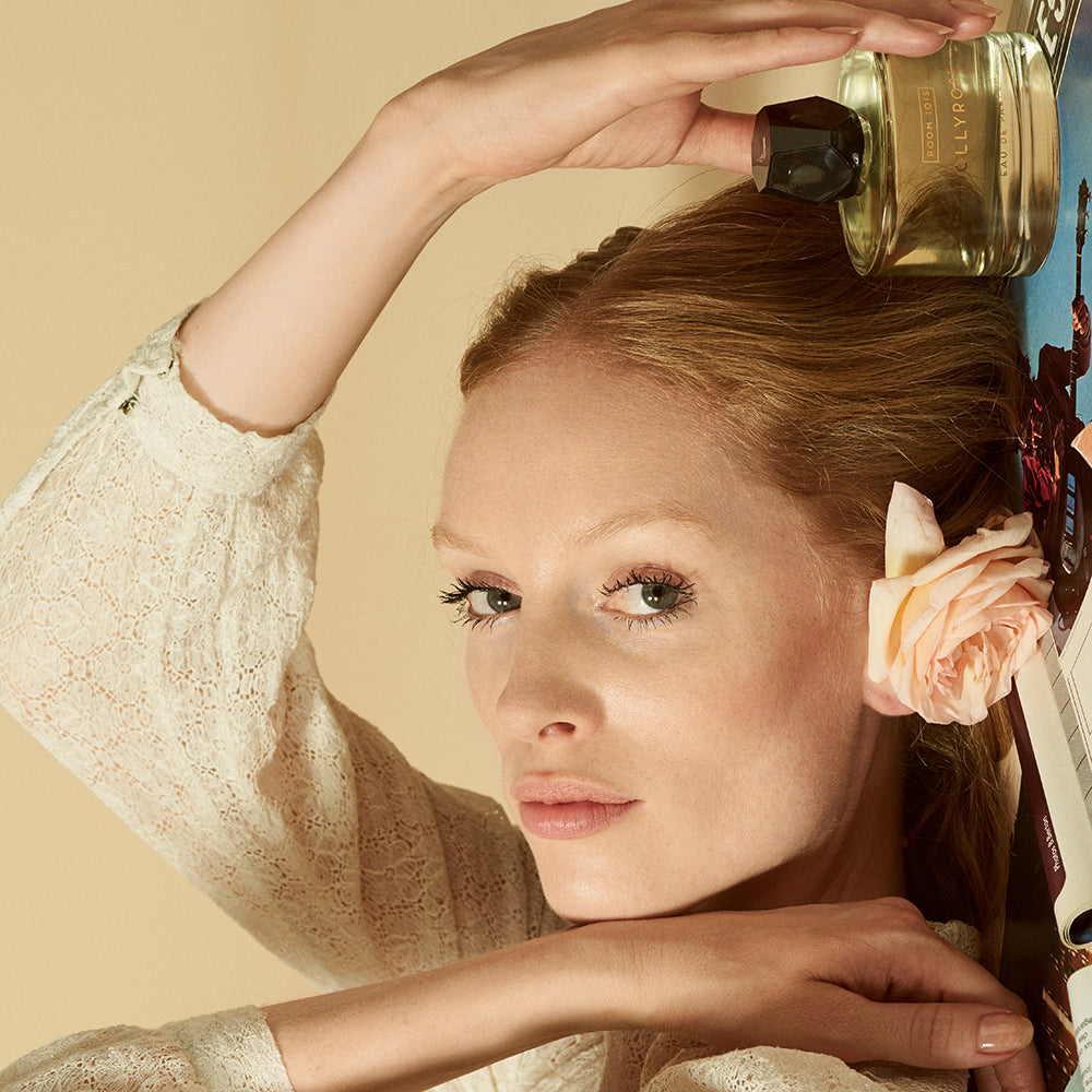 Woman laying down with bottle of Room 1015 Hollyrose - Eau de Parfum