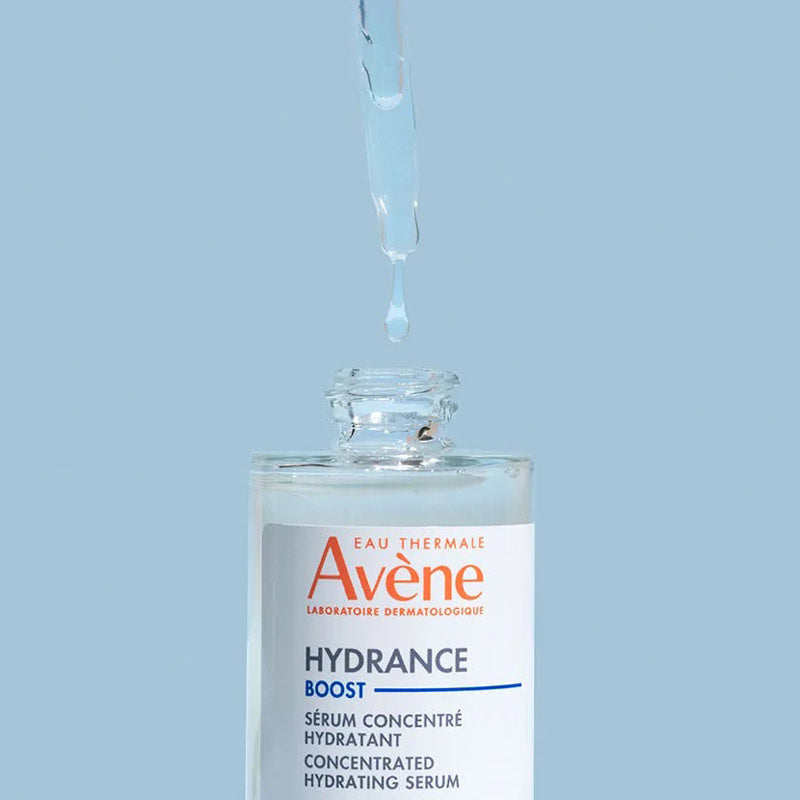 A bottle of Avene Hydrance Boost Serum with a dropper cap, against a blue background.