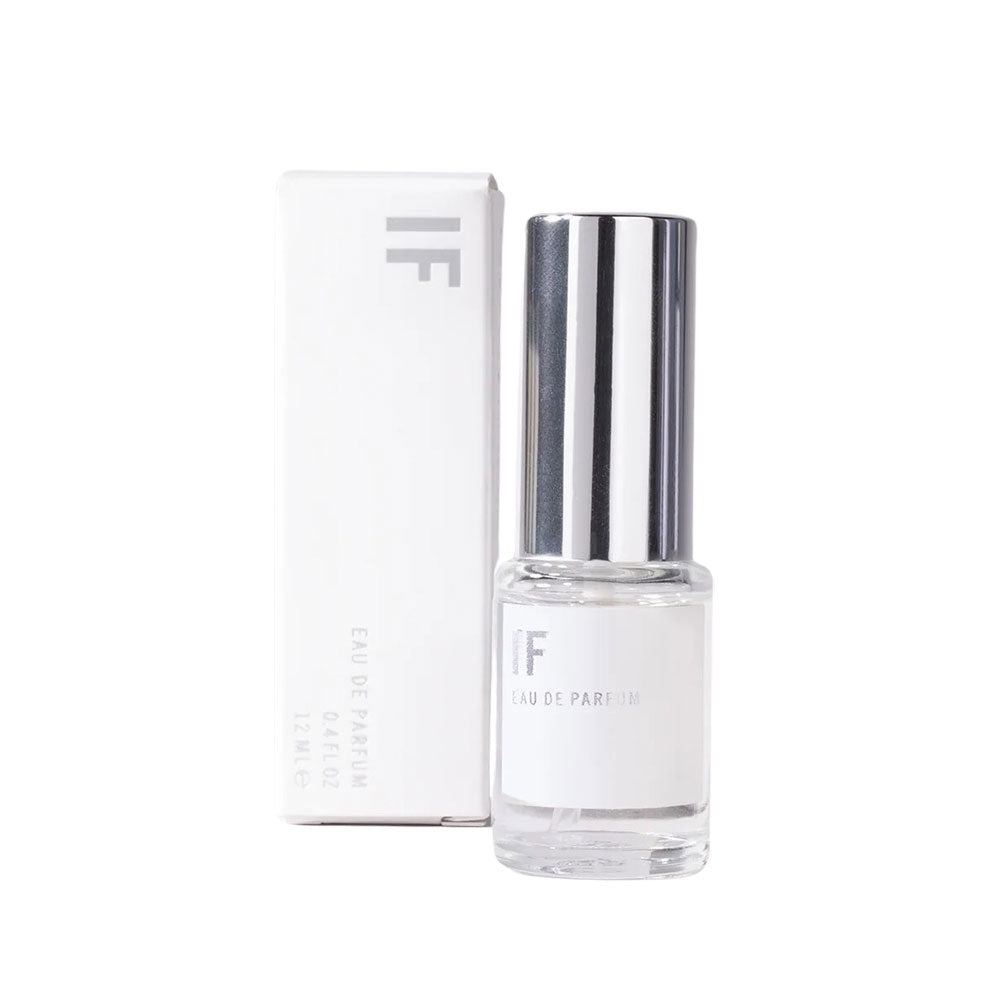 Small perfume bottle next to its box on a white background