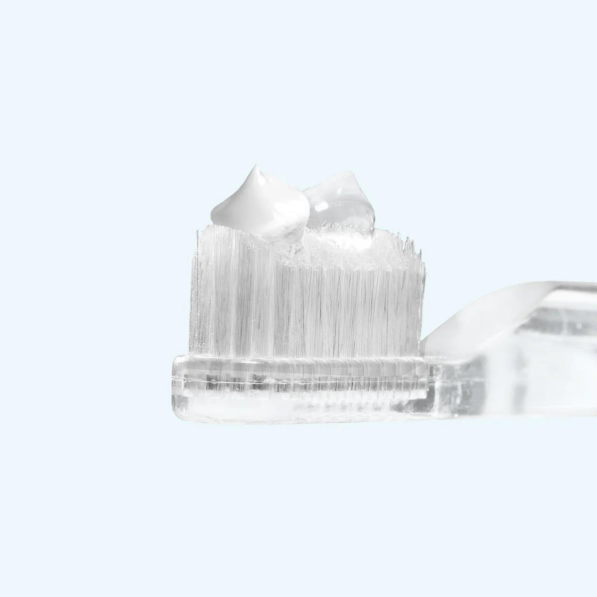 Clear plastic cap with bristle brush on a white background