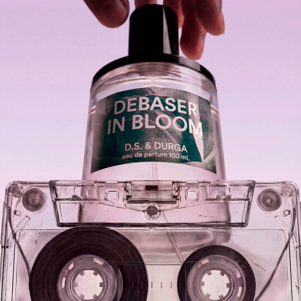 Perfume bottle labeled 'Debaser in Bloom' by D.S. & Durga on a clear cassette tape.