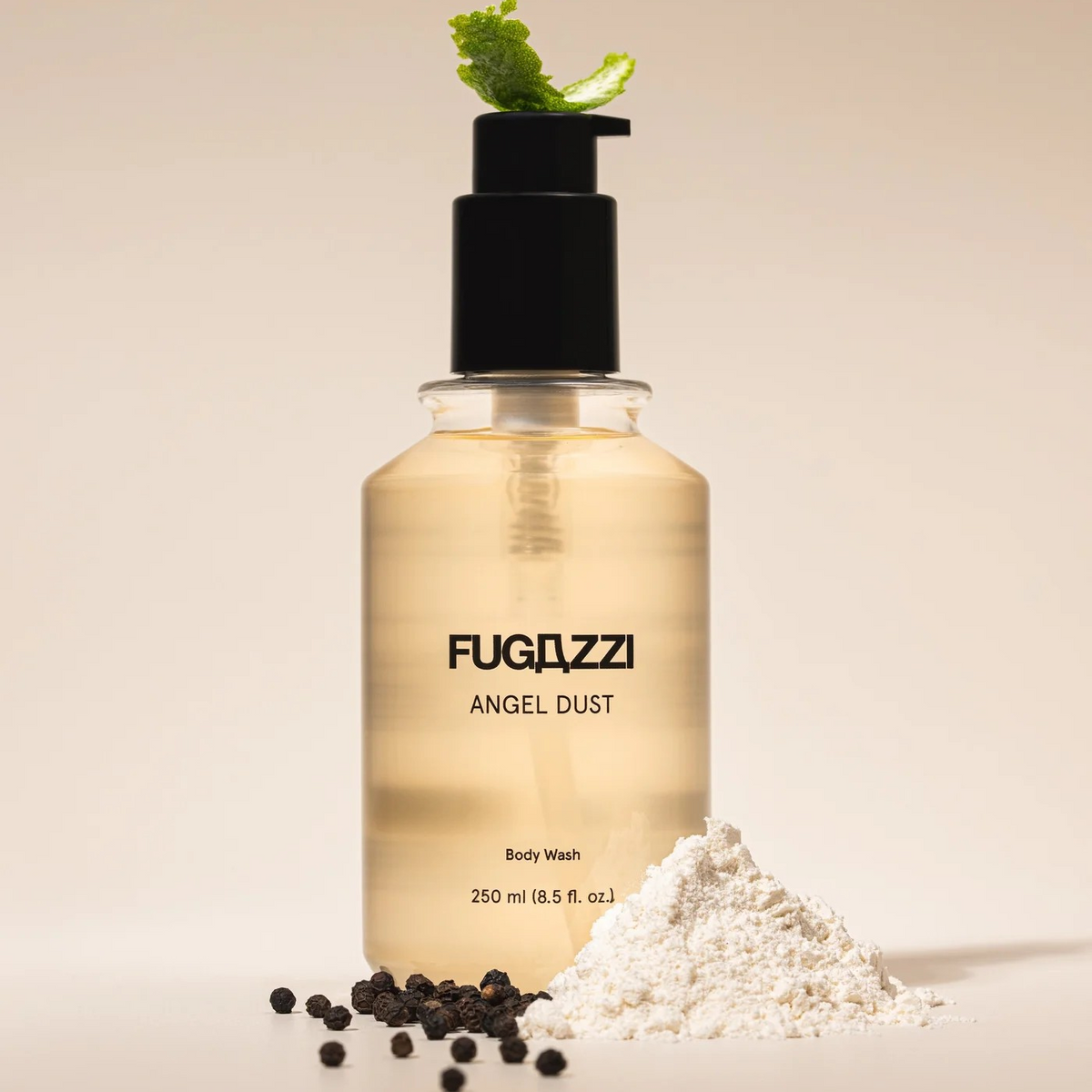 Fugazzi angel dust body wash with a lime peel on top, peppercorns and powder on the bottom.