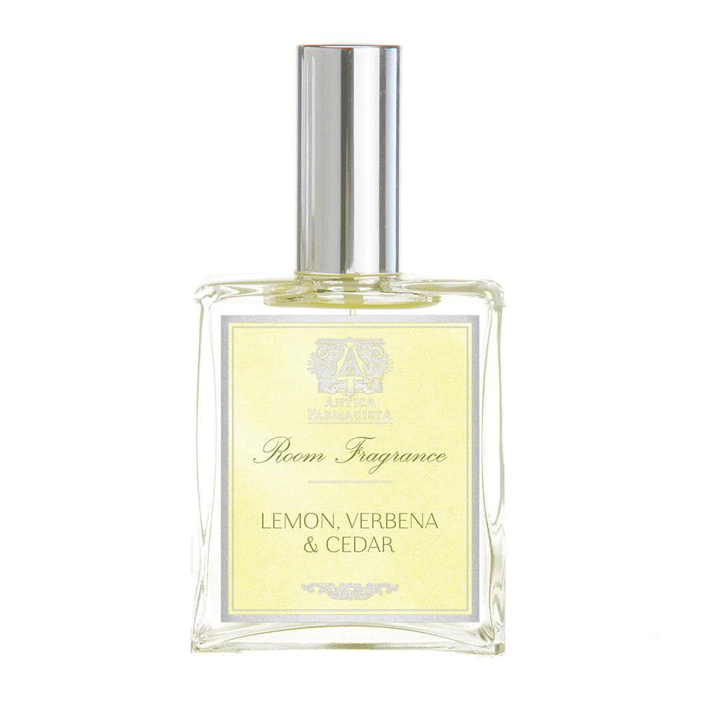 A clear glass bottle of room spray with a yellow label that reads 'LEMON, VERBENA & CEDAR' and the brand 'ANTICA FARMACISTA'.