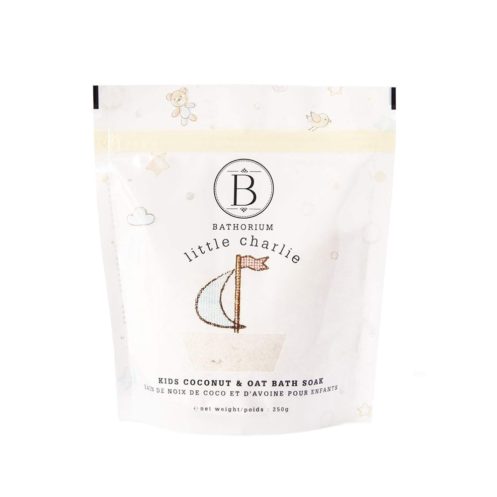 Packaging of Bathorium's Little Charlie bath soak, featuring a white pouch with the brand logo and product name, decorated with subtle cloud and oat illustrations.