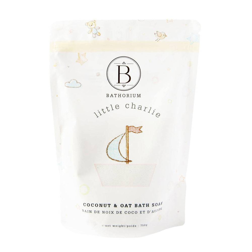 Packaging of Bathorium's Little Charlie bath soak, featuring a white pouch with the brand logo and product name, decorated with subtle cloud and oat illustrations.