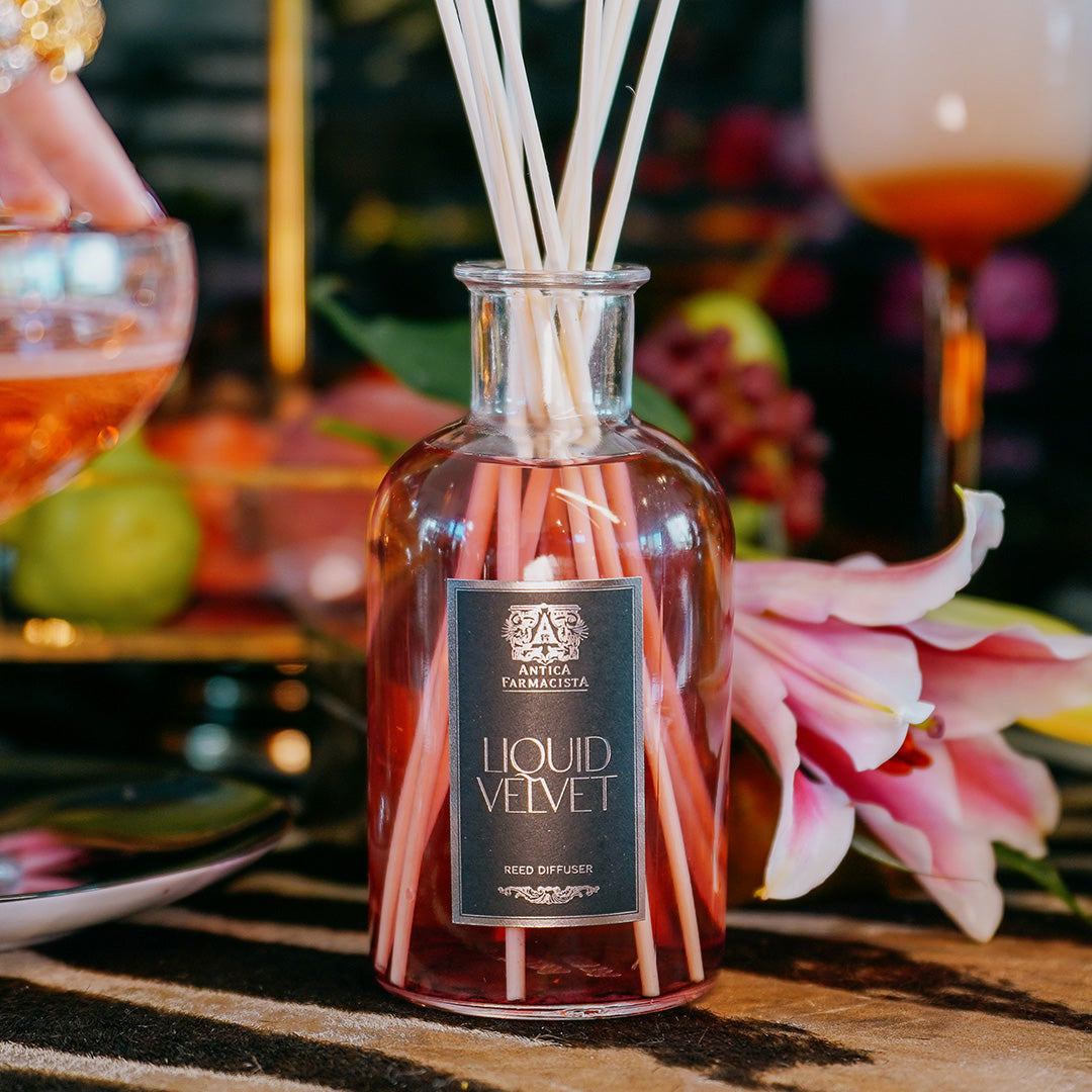 Liquid Velvet diffuser on a table with glasses and flowers